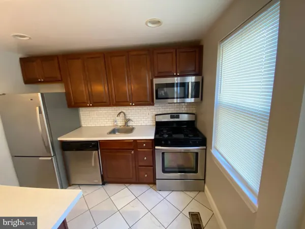 a kitchen with stainless steel appliances a stove a microwave and a sink