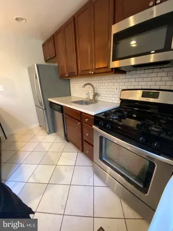 a kitchen with granite countertop a stove and a sink