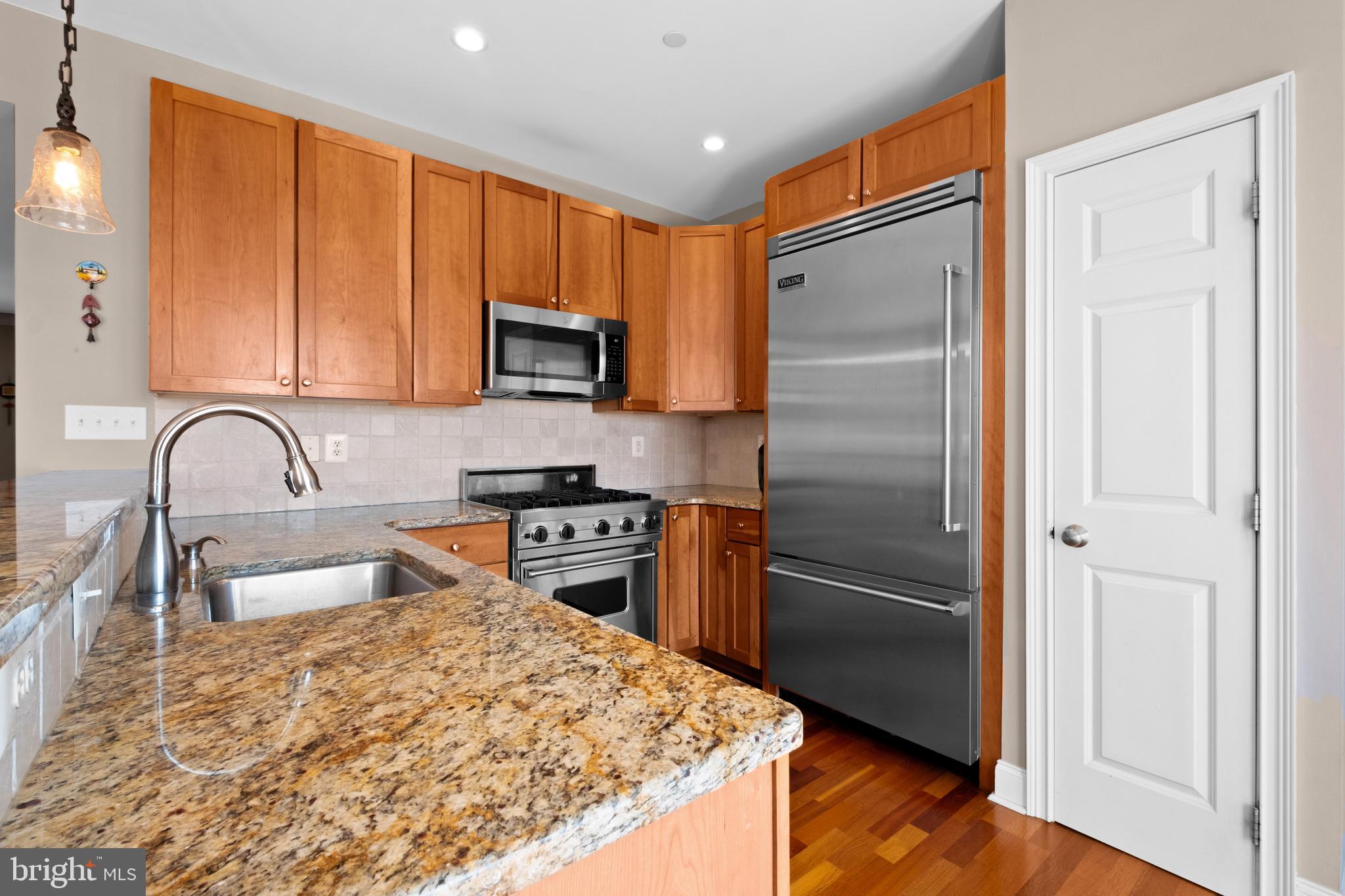 203 Captains Way Philadelphia, PA 19146 - Photo 14 of 58 a kitchen with granite countertop a refrigerator and a stove top oven