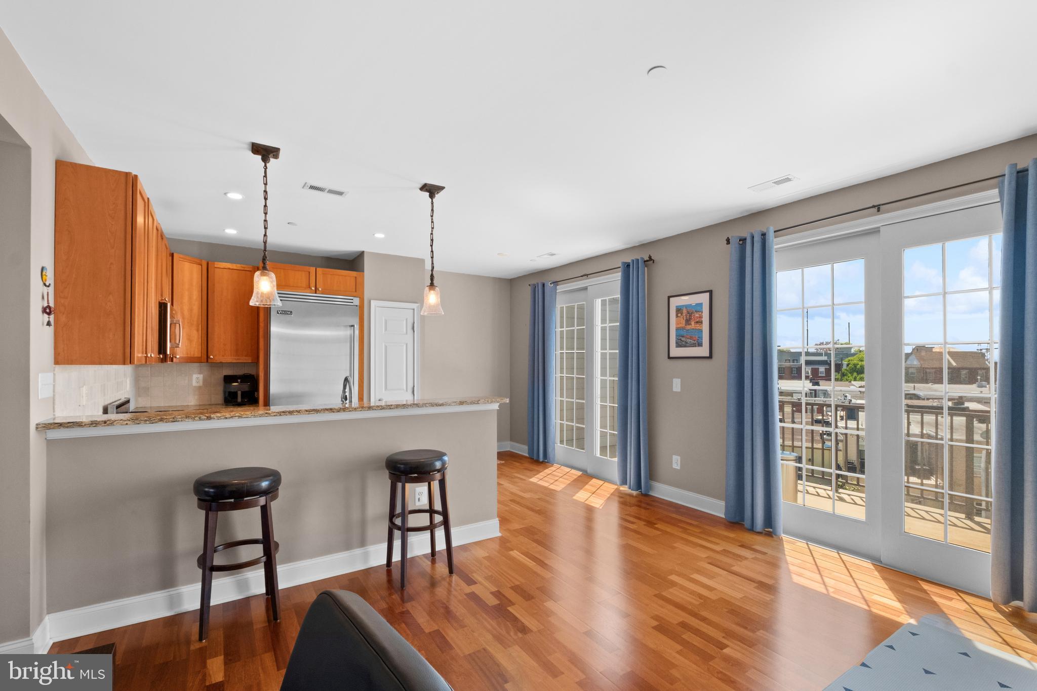 203 Captains Way Philadelphia, PA 19146 - Photo 19 of 58 a open kitchen with stainless steel appliances granite countertop a refrigerator a stove a sink dishwasher with a dining table and chairs with wooden floor