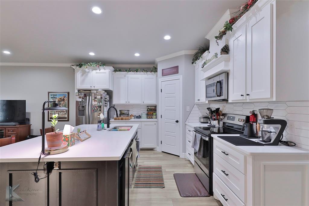 7329 Mountain View Road Abilene, TX 79602 - Photo 11 of 33 a kitchen that has a lot of cabinets a sink and appliances in it