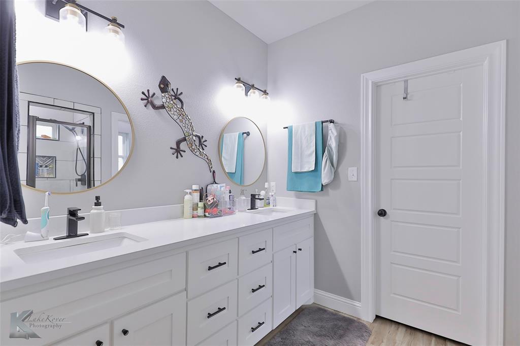 7329 Mountain View Road Abilene, TX 79602 - Photo 19 of 33 a bathroom with a double vanity sink and a mirror