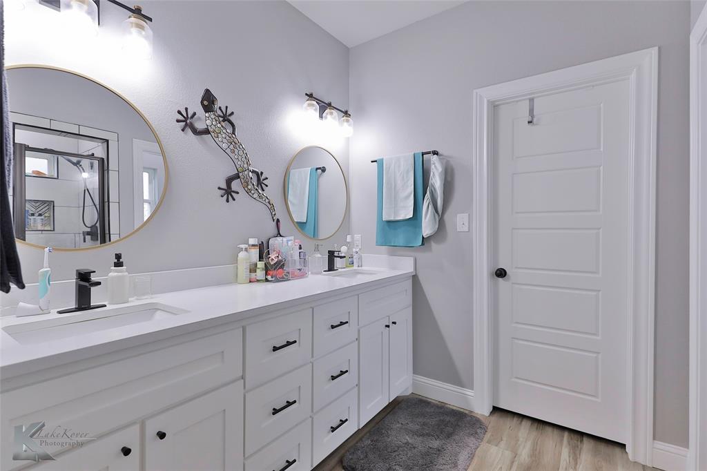 7329 Mountain View Road Abilene, TX 79602 - Photo 20 of 33 a bathroom with a double vanity sink and a mirror