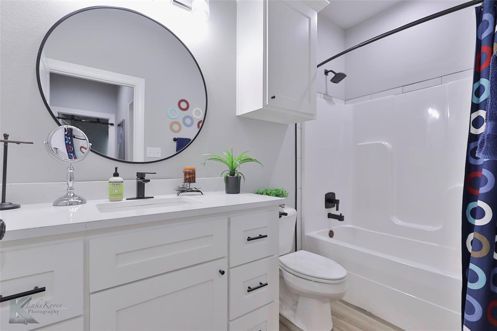 7329 Mountain View Road Abilene, TX 79602 - Photo 26 of 33 a bathroom with a toilet a sink and a mirror