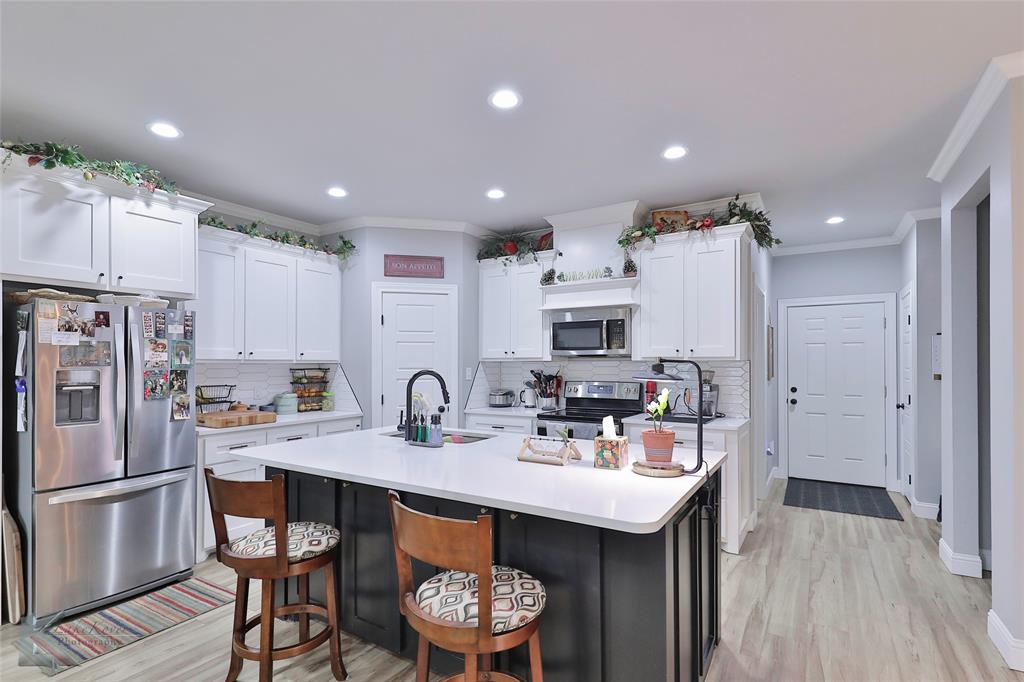 7329 Mountain View Road Abilene, TX 79602 - Photo 8 of 33 a kitchen with stainless steel appliances a sink a stove a refrigerator and cabinets