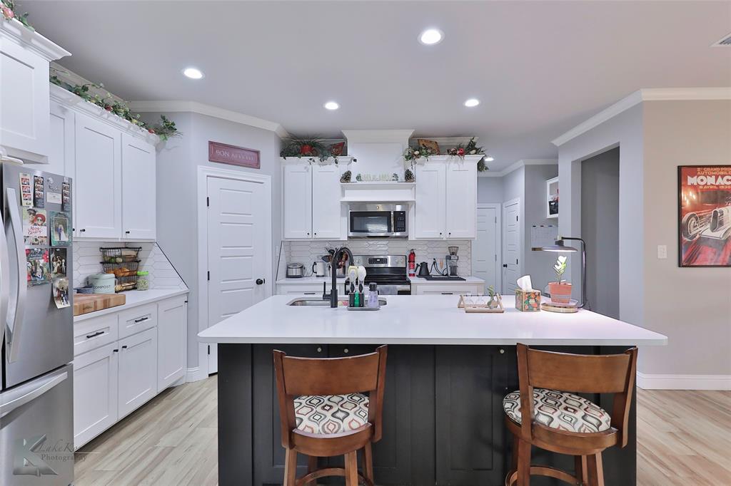 7329 Mountain View Road Abilene, TX 79602 - Photo 9 of 33 a kitchen with stainless steel appliances kitchen island granite countertop a sink cabinets and wooden floor