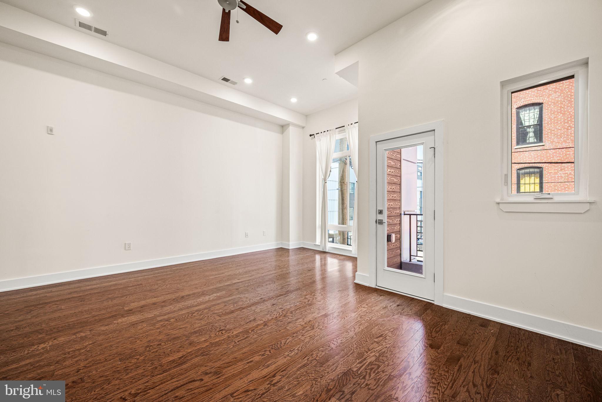 1115 North American Street, Unit D5 Philadelphia, PA 19123 - Photo 19 of 52 an empty room with wooden floor and windows