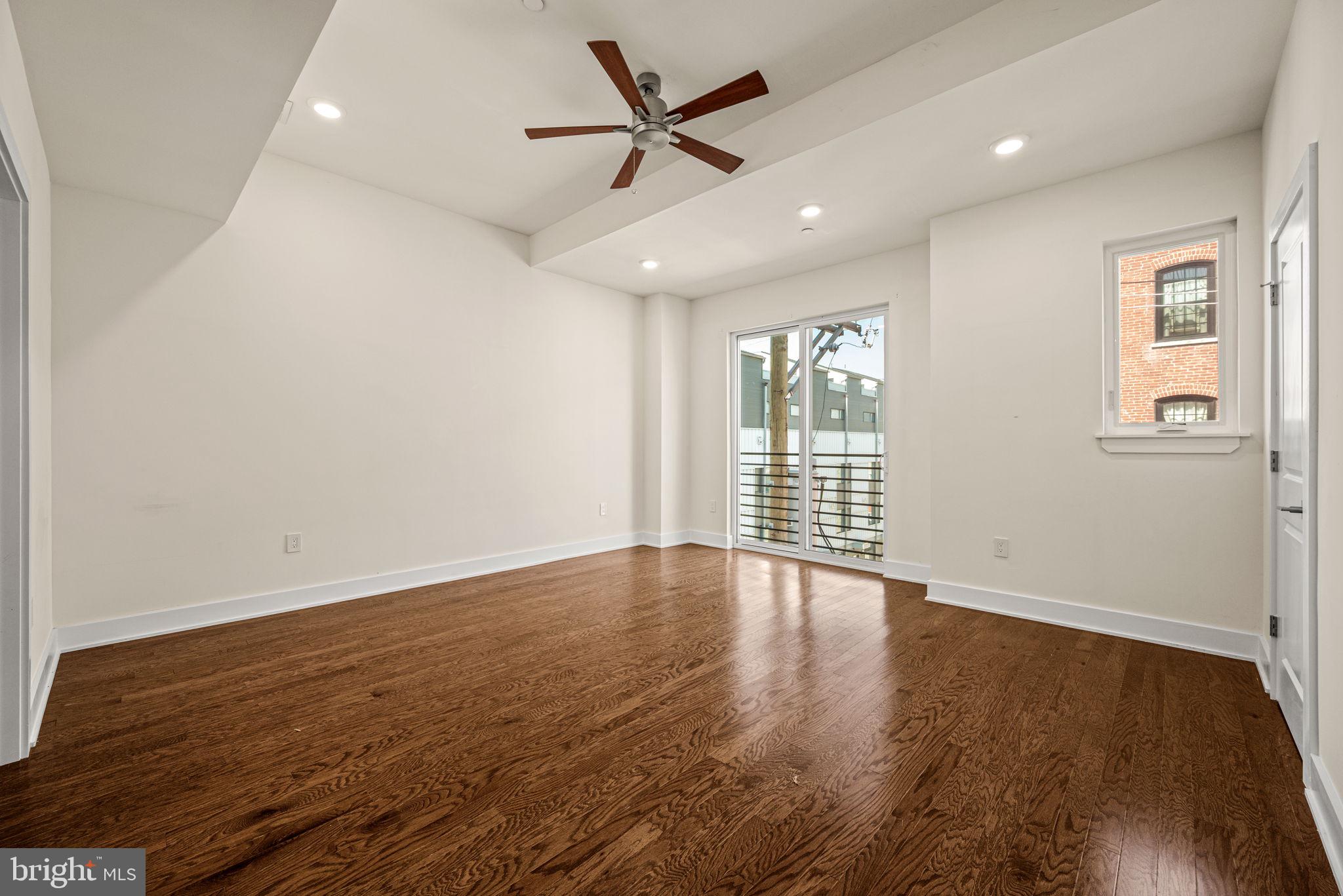 1115 North American Street, Unit D5 Philadelphia, PA 19123 - Photo 25 of 52 an empty room with wooden floor and windows
