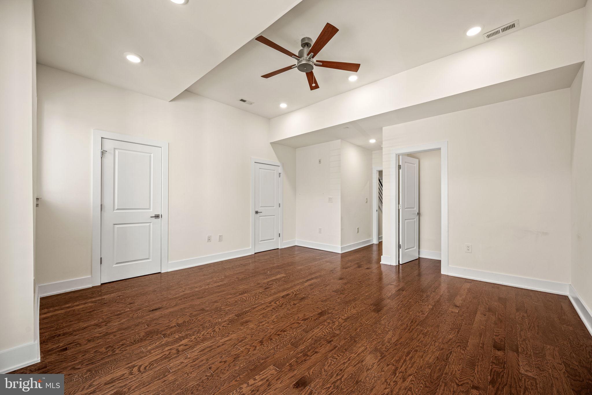1115 North American Street, Unit D5 Philadelphia, PA 19123 - Photo 27 of 52 an empty room with wooden floor and a ceiling fan