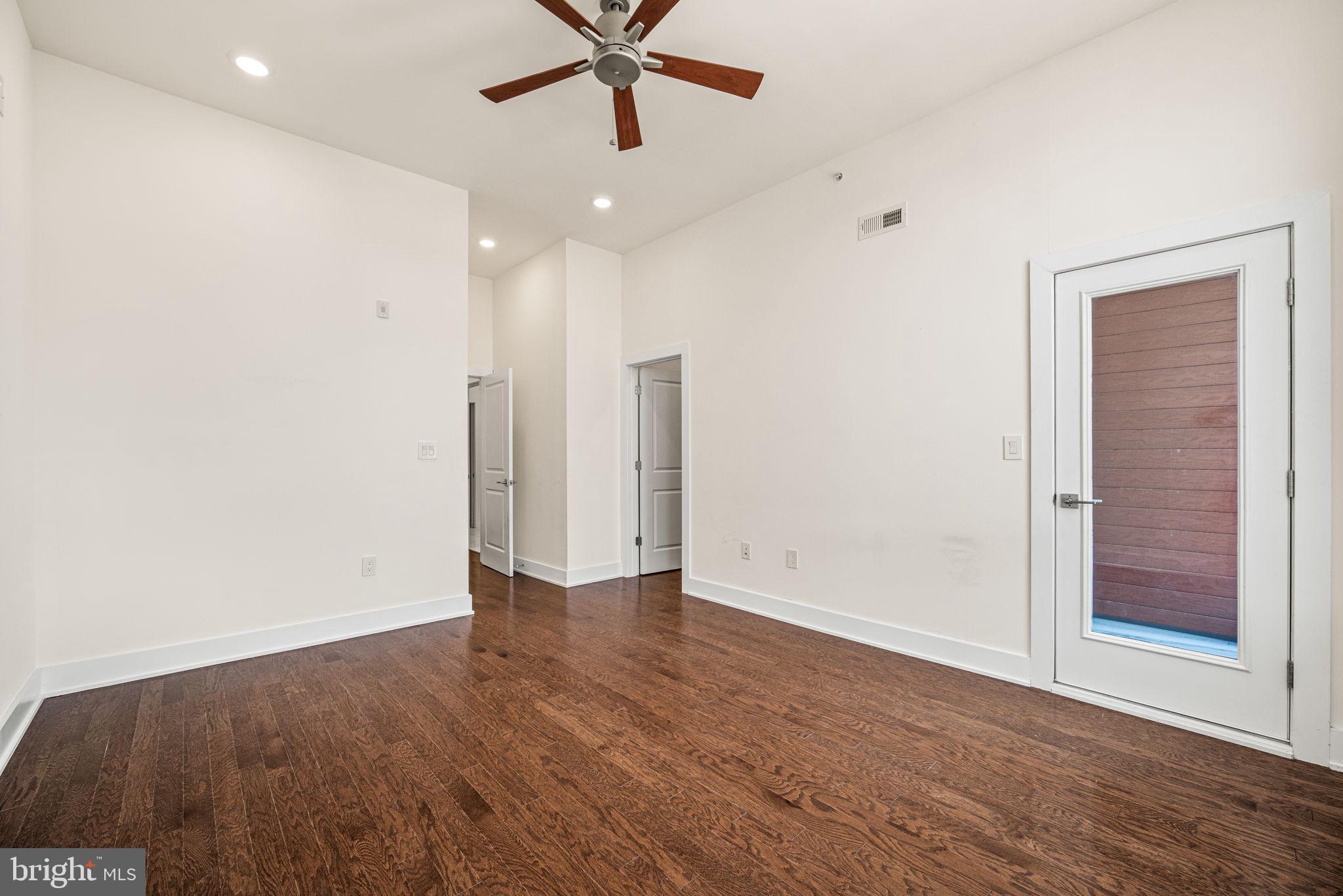 1115 North American Street, Unit D5 Philadelphia, PA 19123 - Photo 35 of 52 an empty room with wooden floor and windows