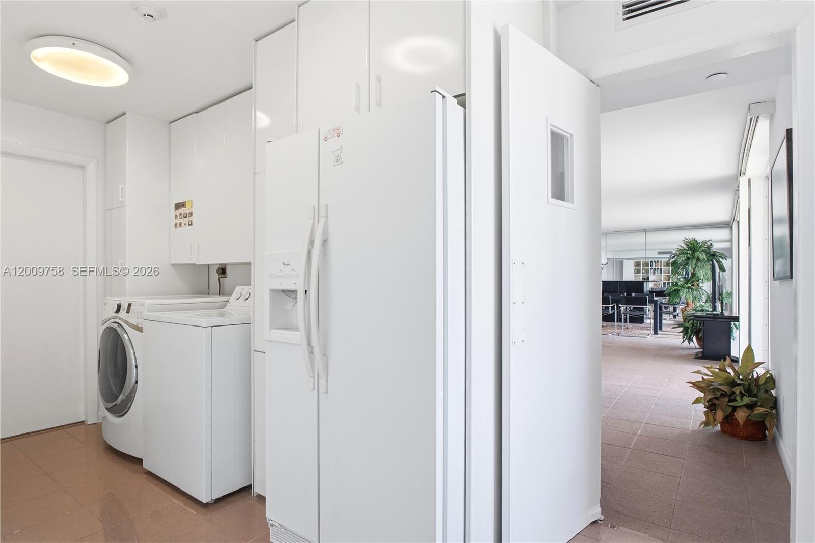 605 Ocean Drive, Unit 7L Key Biscayne, FL 33149 - Photo 22 of 38 a view of washer and dryer with kitchen in the background