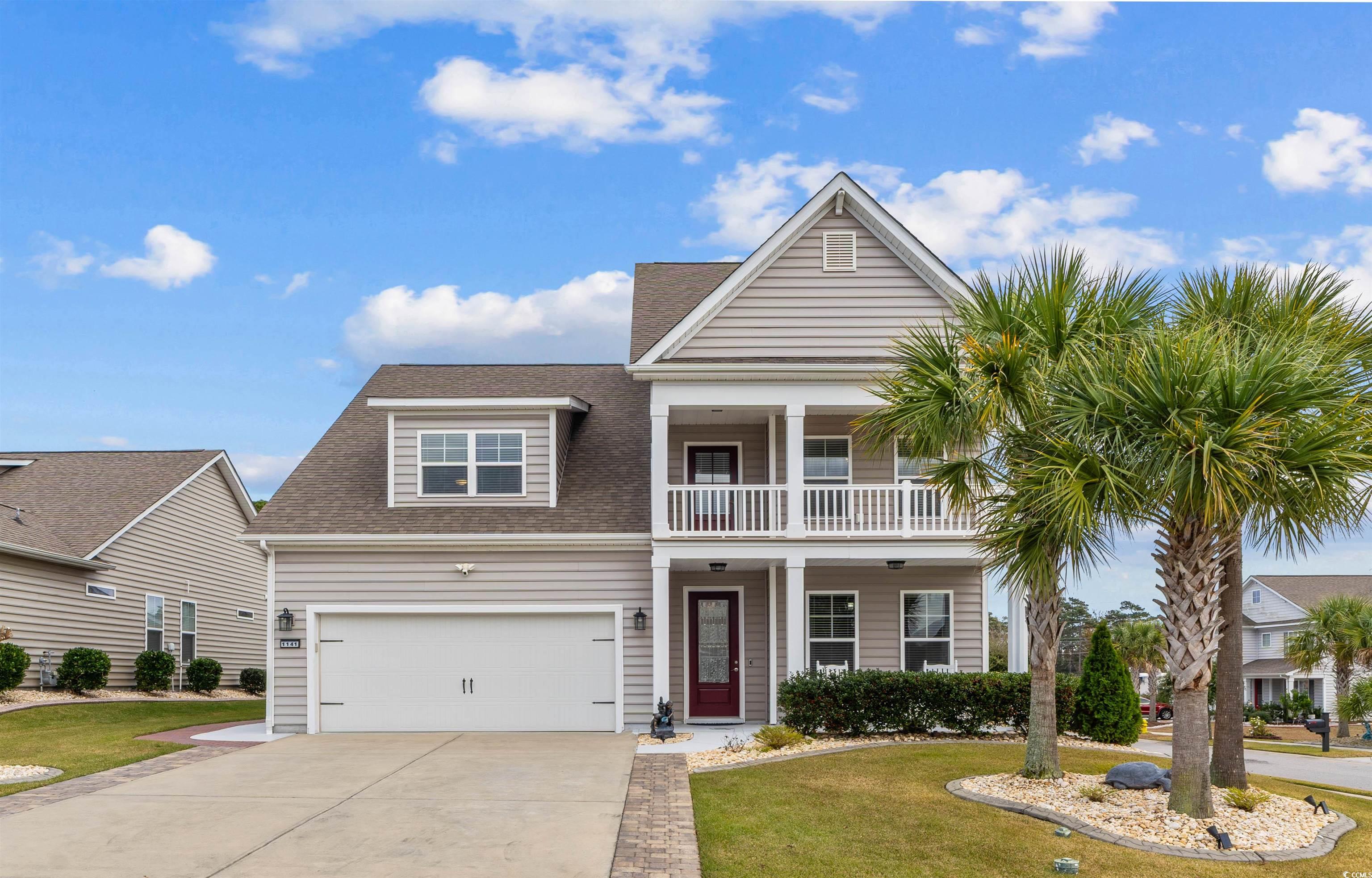 View of front of property with roof with shingles, a front lawn, driveway, and covered porch
