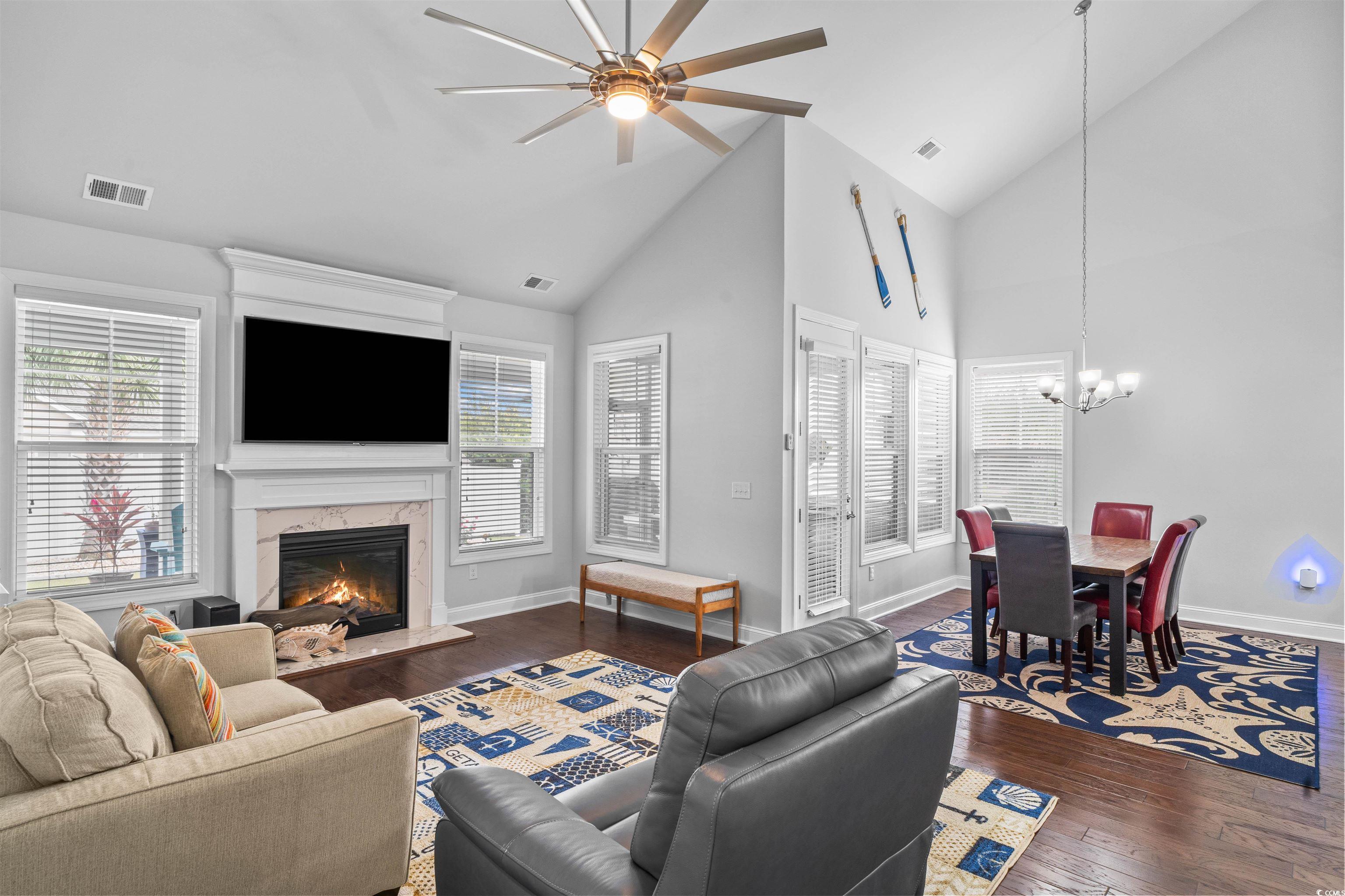 1141 Bronwyn Circle North Myrtle Beach, SC 29582 - Photo 17 of 40 Living area featuring high vaulted ceiling, ceiling fan, dark wood finished floors, a high end fireplace, and a chandelier