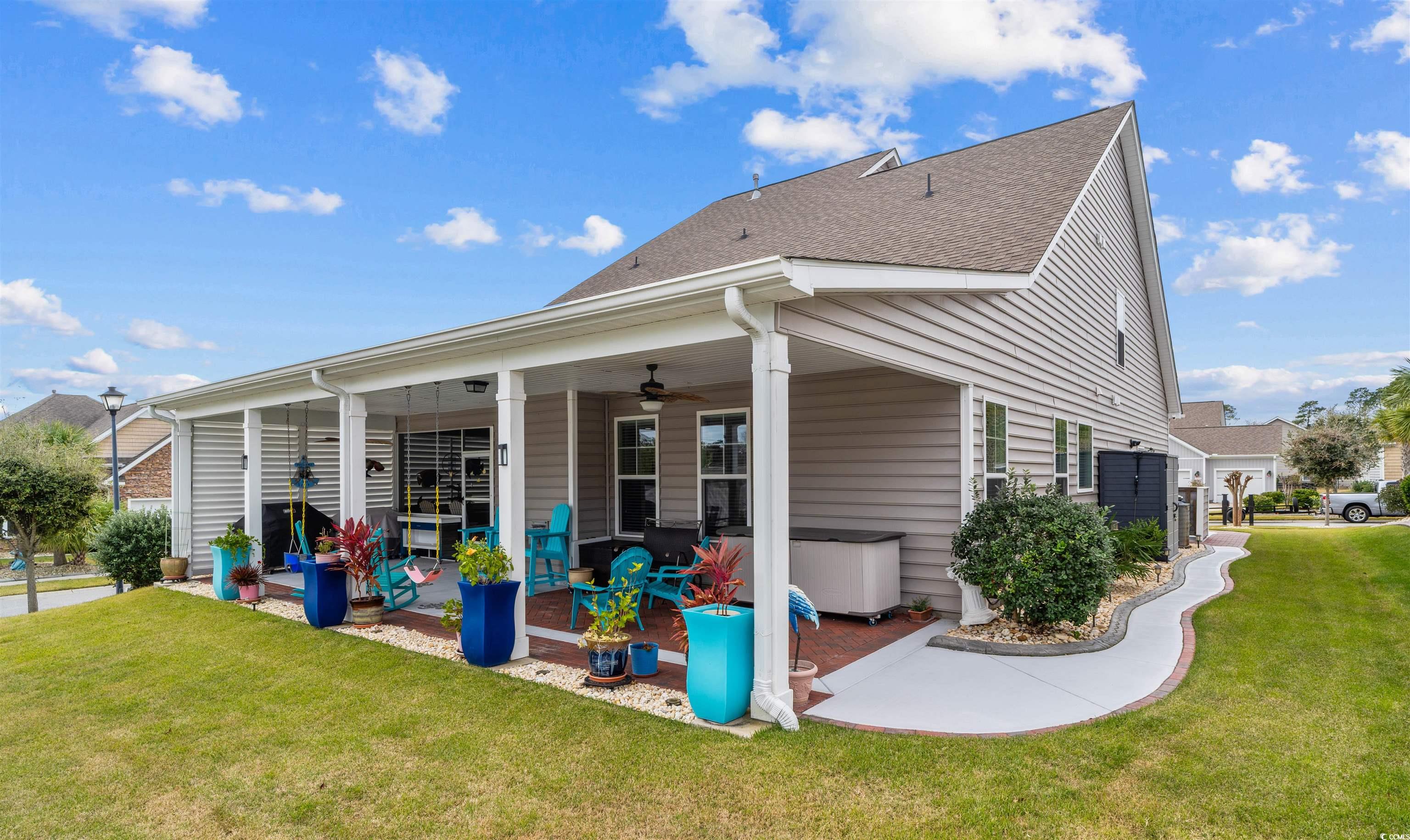 1141 Bronwyn Circle North Myrtle Beach, SC 29582 - Photo 2 of 40 Back of property featuring a yard, a ceiling fan, roof with shingles, and a patio area