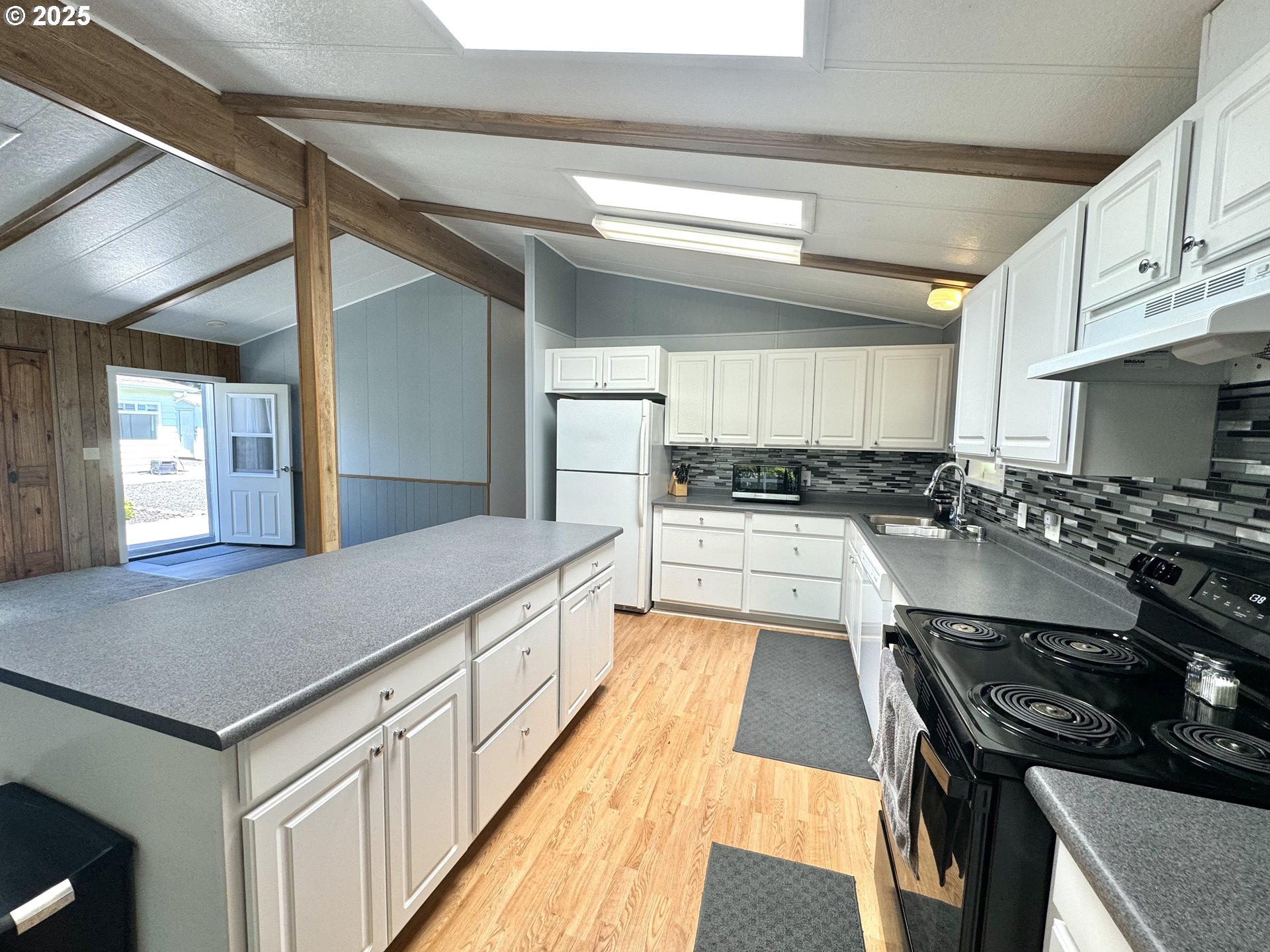 1601 Rhododendron Drive, Unit 676 Florence, OR 97439 - Photo 12 of 36 a kitchen with stainless steel appliances granite countertop a stove and a sink