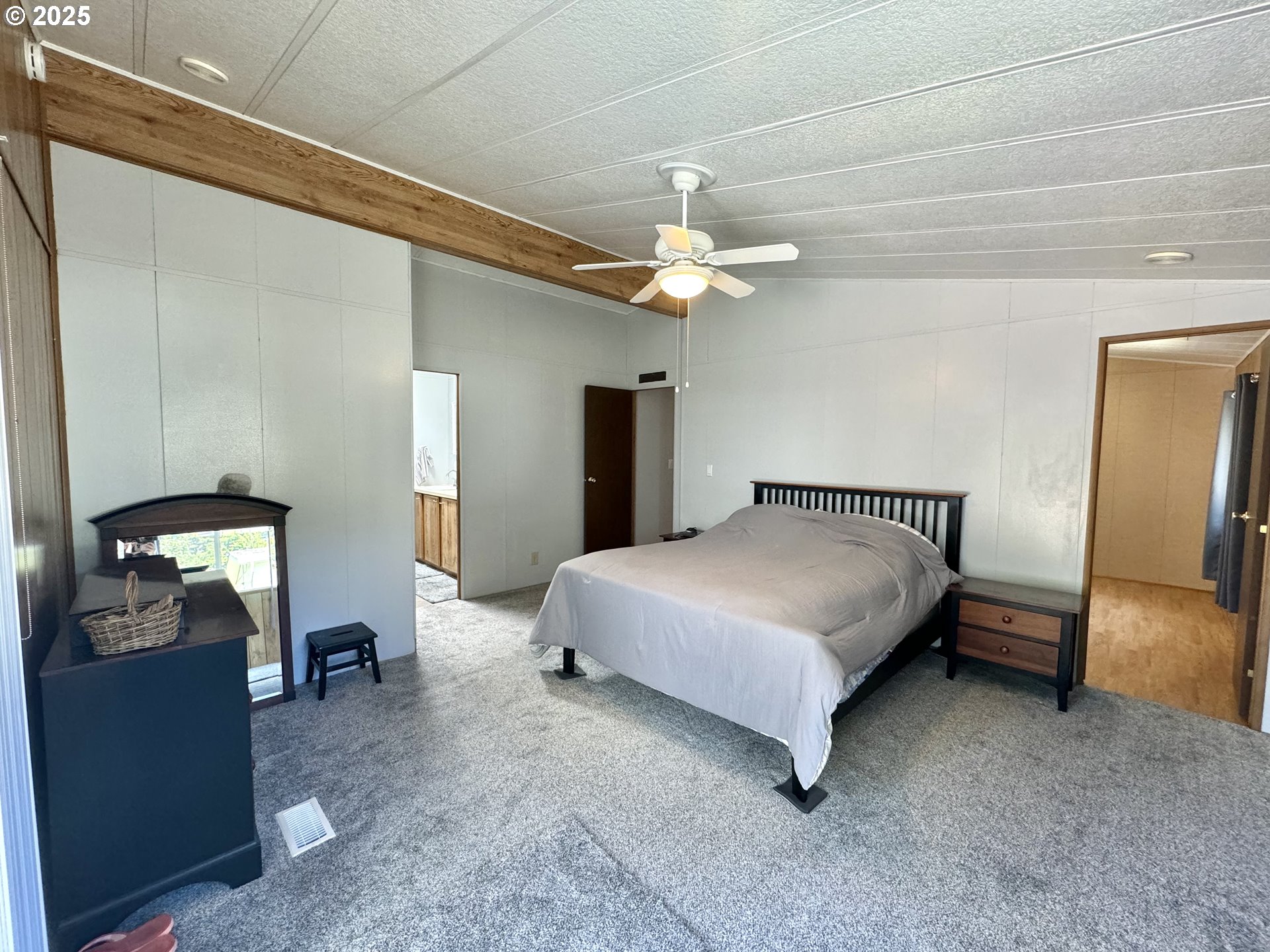1601 Rhododendron Drive, Unit 676 Florence, OR 97439 - Photo 17 of 36 a spacious bedroom with a bed and a chandelier