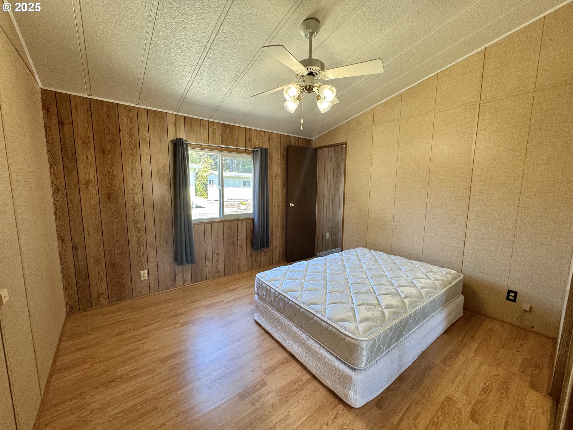 1601 Rhododendron Drive, Unit 676 Florence, OR 97439 - Photo 23 of 36 a spacious bedroom with a bed and a chandelier