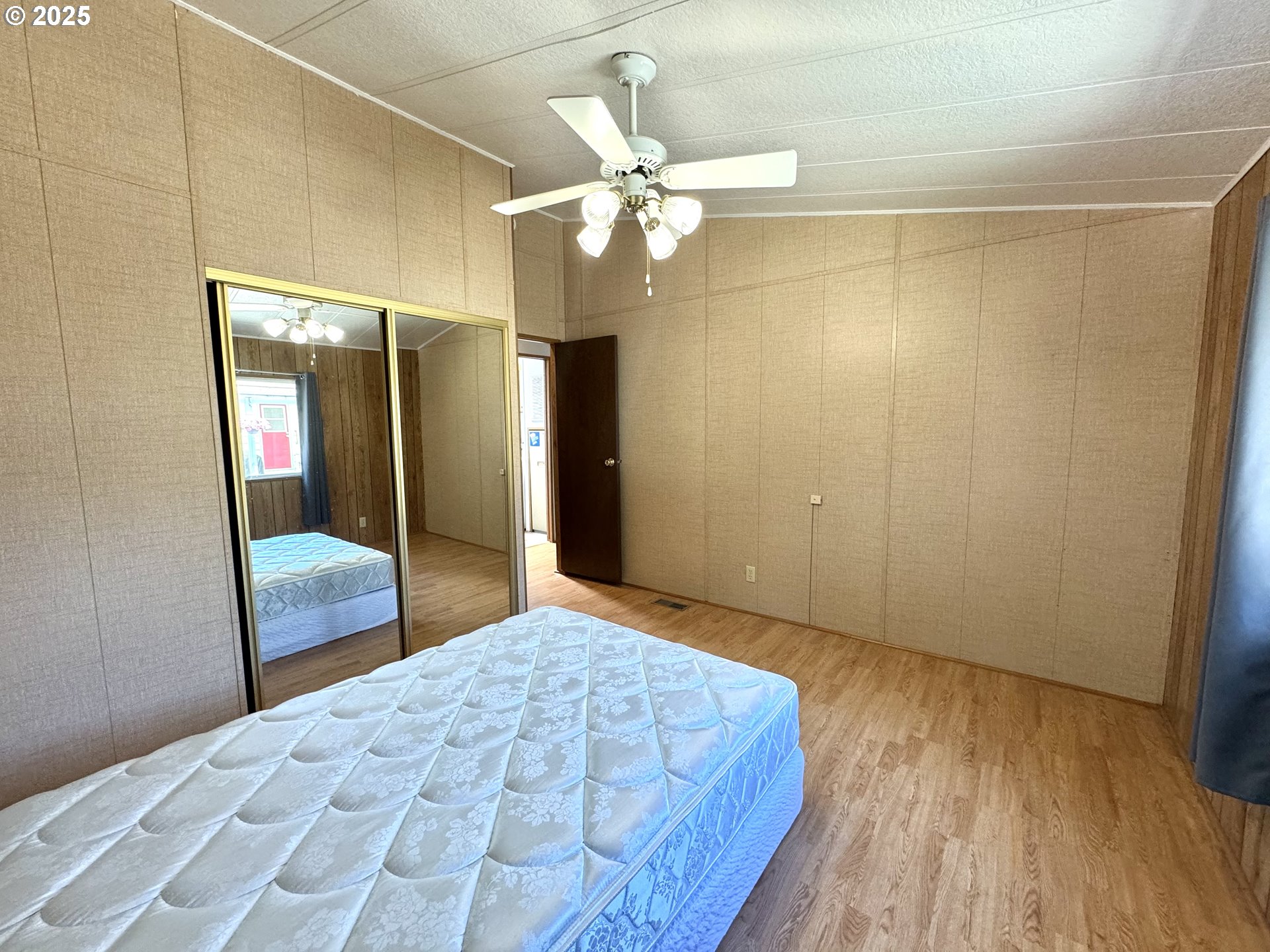 1601 Rhododendron Drive, Unit 676 Florence, OR 97439 - Photo 24 of 36 a bedroom with a large bed and a chandelier