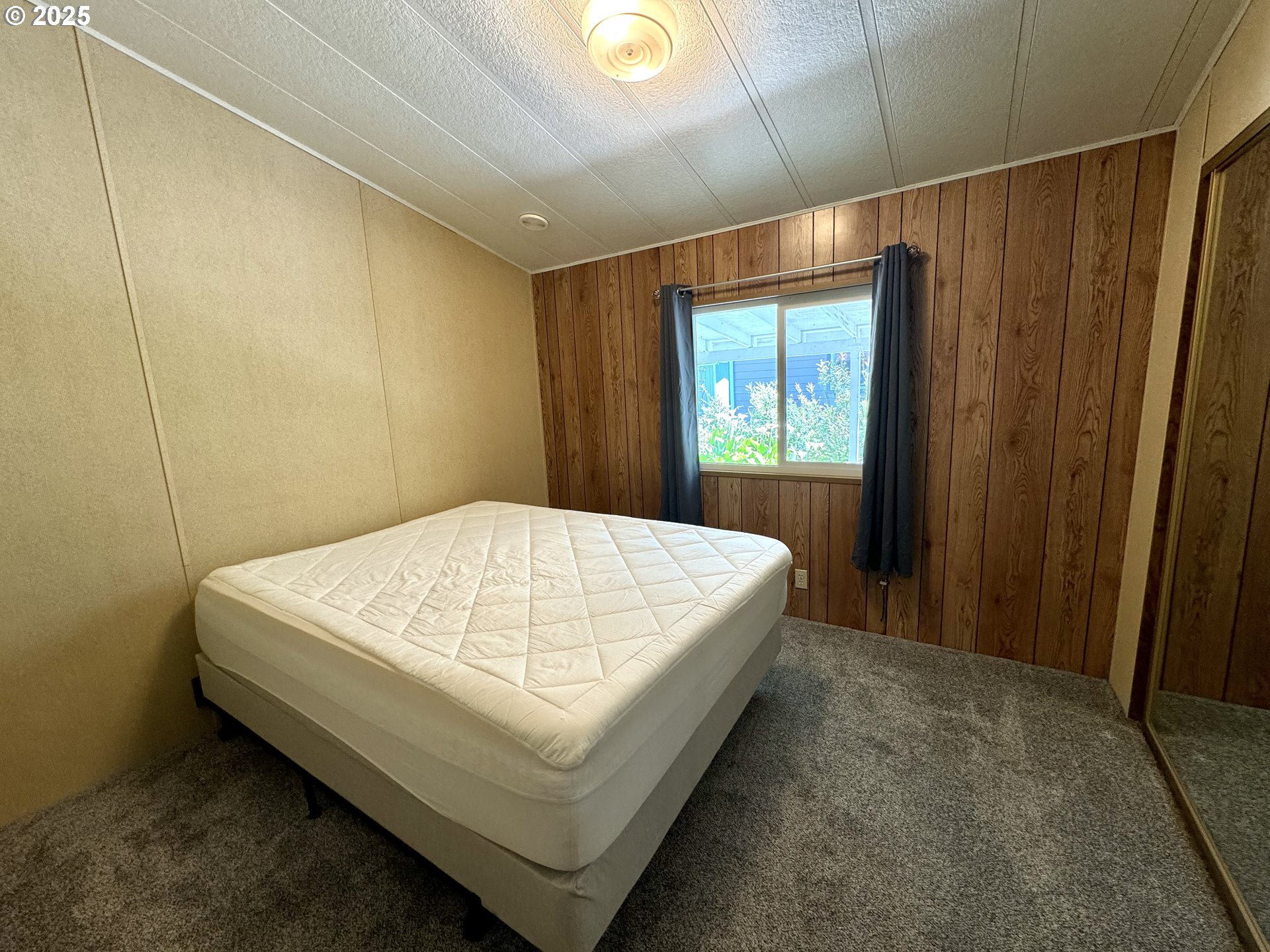 1601 Rhododendron Drive, Unit 676 Florence, OR 97439 - Photo 26 of 36 a bed sitting in a room next to a window