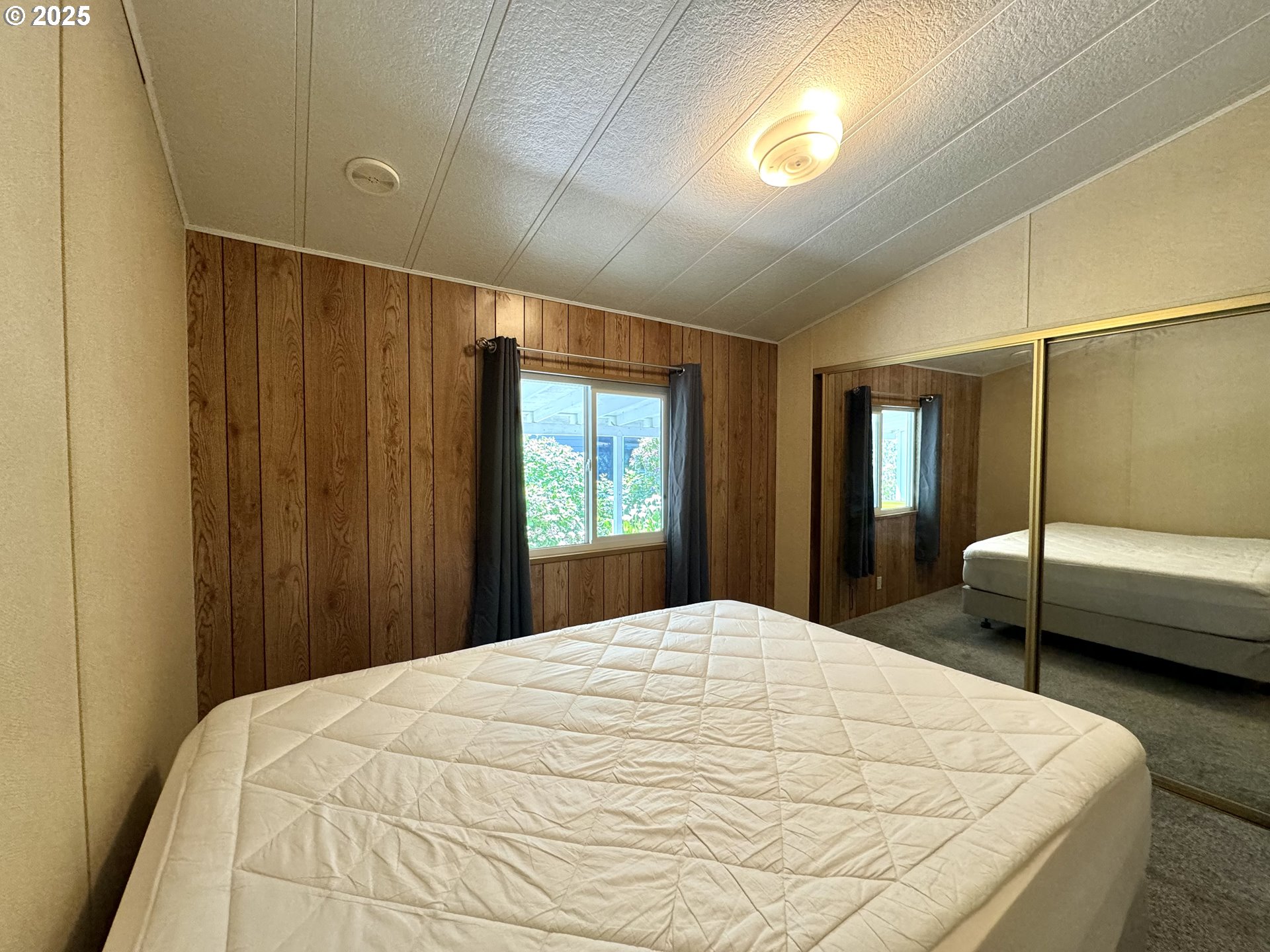 1601 Rhododendron Drive, Unit 676 Florence, OR 97439 - Photo 27 of 36 a bedroom with a bed and a large window