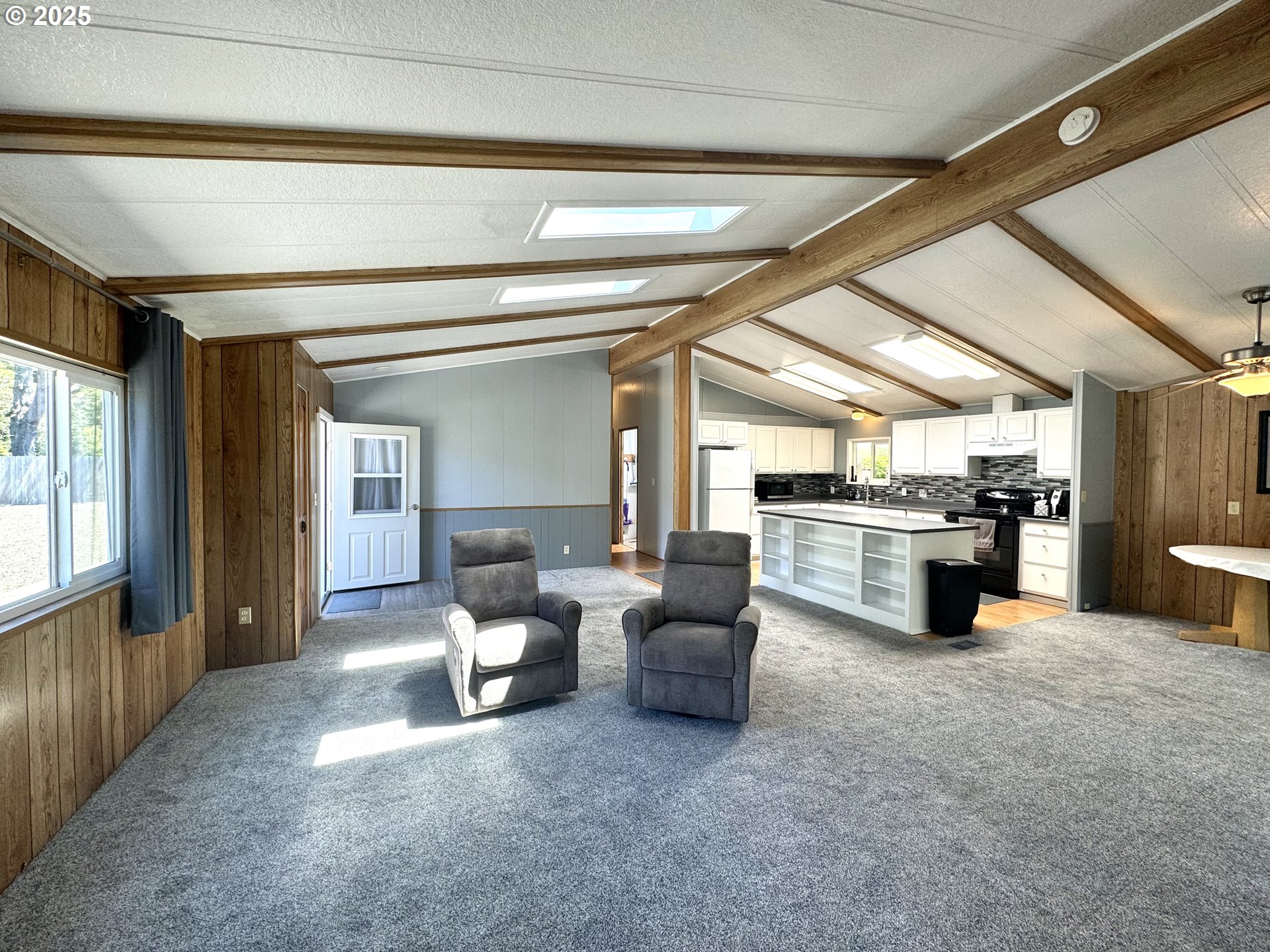 1601 Rhododendron Drive, Unit 676 Florence, OR 97439 - Photo 7 of 36 a living room with couches and kitchen view