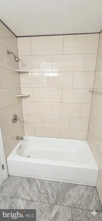 a bathroom with a bathtub and shower