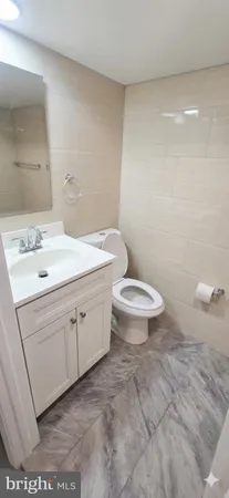a bathroom with a sink a toilet and a mirror