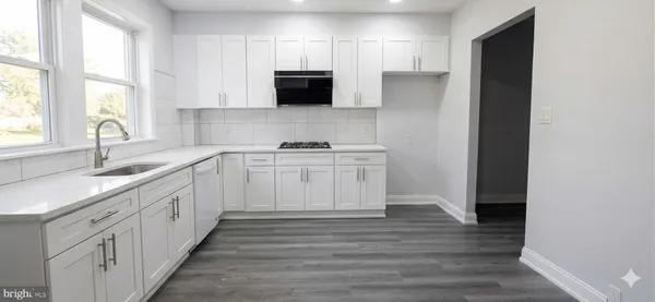 a kitchen with a sink cabinets appliances and a window