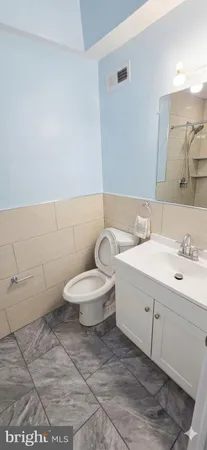 a bathroom with a toilet sink and mirror