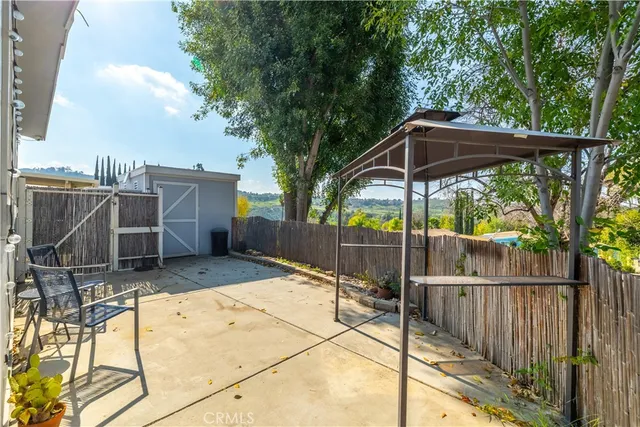 a view of a house with backyard and wooden fence