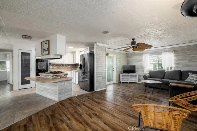 a kitchen with a refrigerator a stove top oven a sink dishwasher and white cabinets with wooden floor