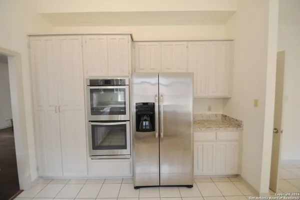 a metallic refrigerator freezer and a refrigerator in a kitchen