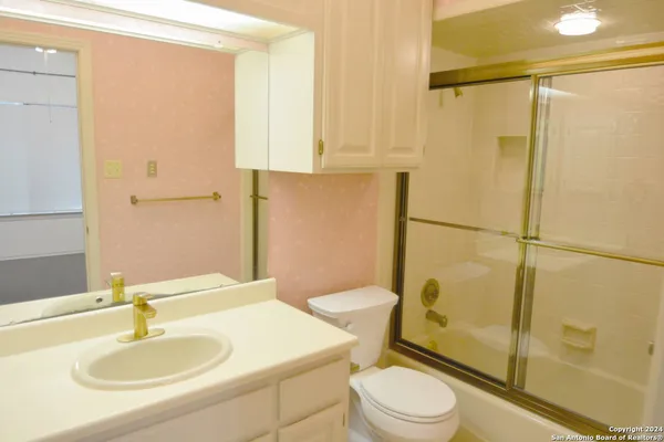 a bathroom with a sink a toilet and shower