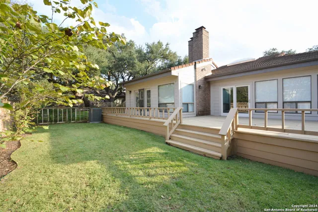 a view of a house with a backyard and a patio