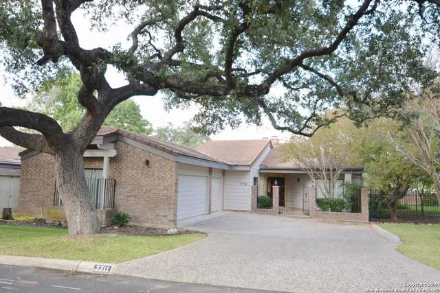 a front view of a house with a garden and trees