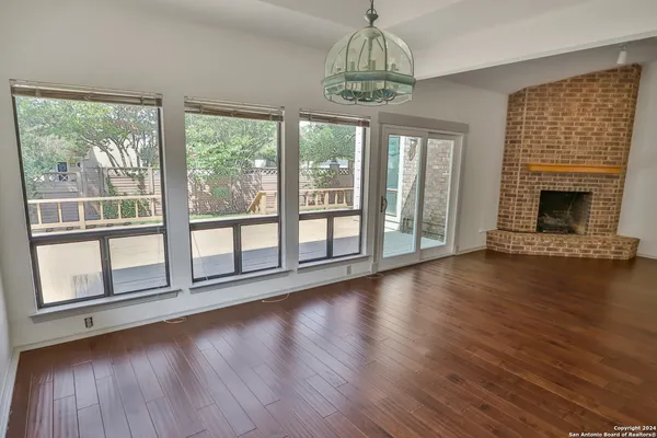 a view of empty room with wooden floor and fireplace