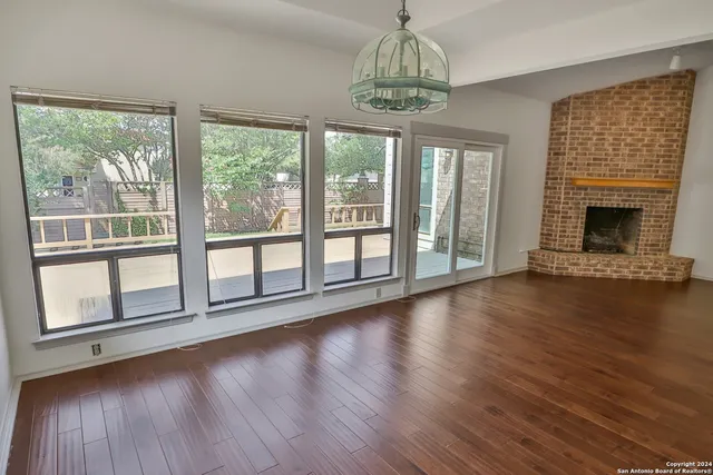 a view of empty room with wooden floor and fireplace