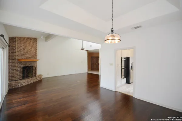 a hallway with wooden floor fireplace and window