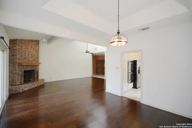 a hallway with wooden floor fireplace and window