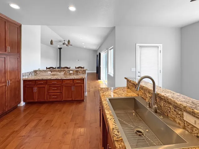 a kitchen with stainless steel appliances granite countertop a stove a sink and a refrigerator