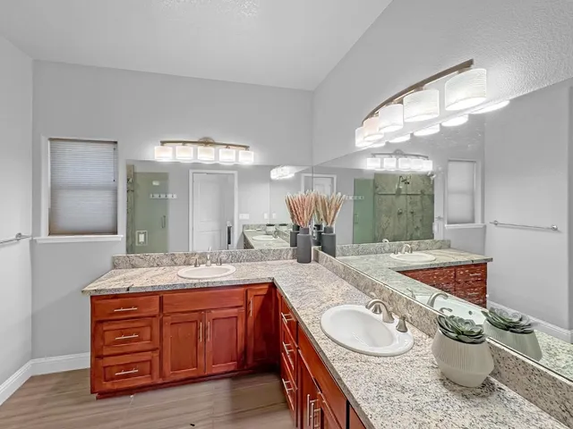 a bathroom with a granite countertop sink and a mirror