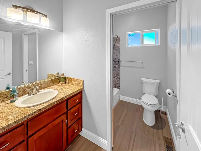 a bathroom with a toilet sink and mirror