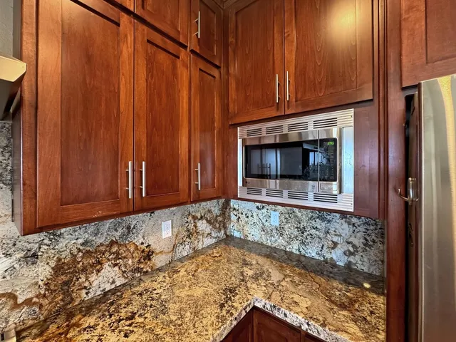 a view of empty room with a fireplace and wooden walls