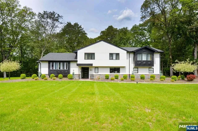 a view of a house with a big yard plants and large trees