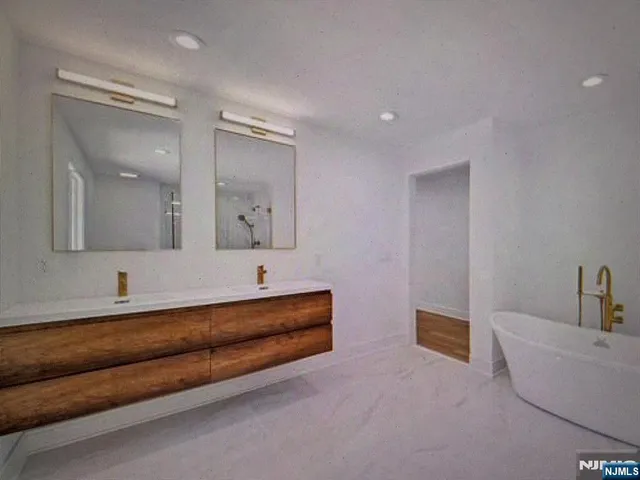 a spacious bathroom with a double vanity sink mirror and bathtub