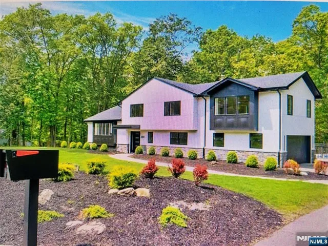 a front view of a house with a yard and trees