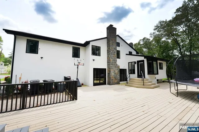 a view of a house with wooden deck and a backyard
