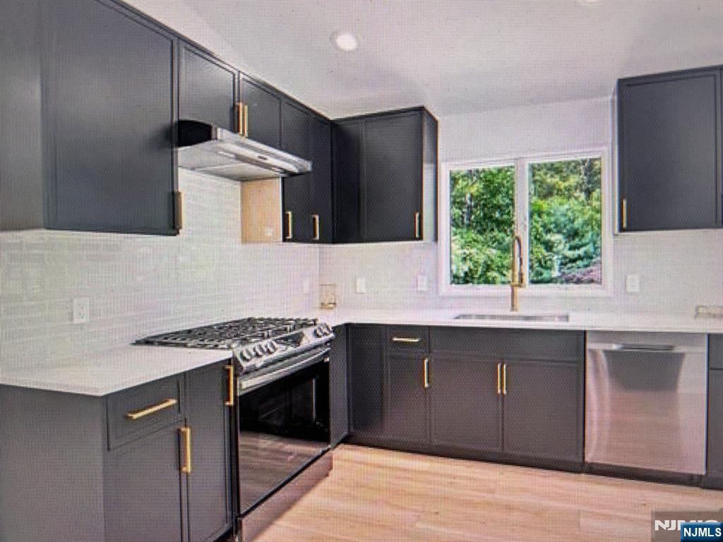 880 Briarwoods Road Franklin Lakes, NJ 07417 - Photo 7 of 27 a kitchen with stainless steel appliances granite countertop a stove a sink and a microwave