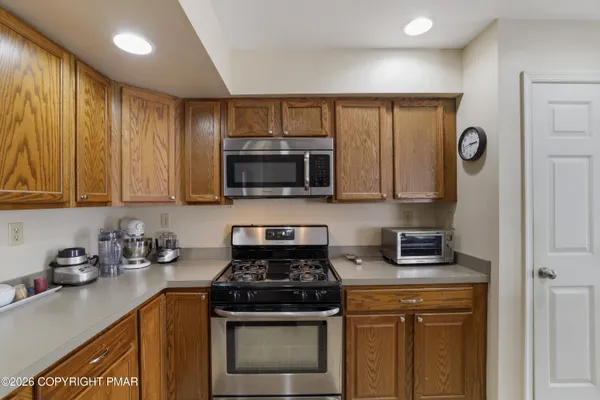 a kitchen with stainless steel appliances granite countertop a stove a sink and a microwave