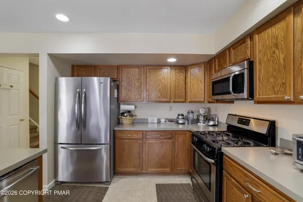 a kitchen with stainless steel appliances a refrigerator stove microwave sink and cabinets